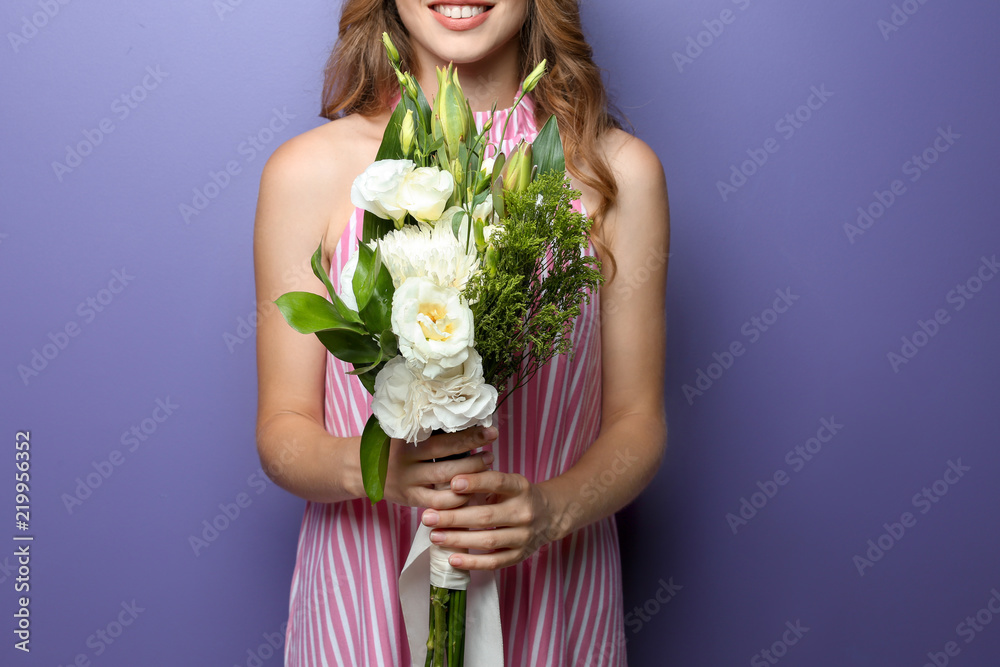 Young woman with beautiful flowers on color background