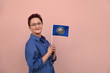 New Hampshire flag. Woman holding  New Hampshire state flag. Nice portrait of middle aged lady 40 50 years old with a state flag over pink wall on the street outdoors.