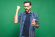 © denis_vermenko - I'm a winner! Happy man holding smartphone and celebrating his success over green background.