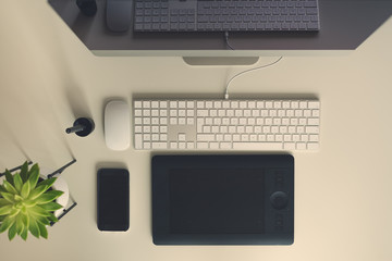 Wall Mural - White office desk table with computer keyboard, mouse, monitor, graphic tablet, smartphone, succulent plant and other office supplies. Top view, copy space, flat lay.