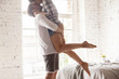 © fizkes - Close up of happy boyfriend holding beloved girlfriend in arms, romantic millennial couple hugging kissing in bedroom, man lifting up lover enjoying passionate dance at home, spouses relax swirling