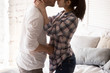 © fizkes - Close up of sensual young couple undress in bedroom having foreplay before sex, lovers kiss and hug on passionate prelude before love making, boyfriend and girlfriend enjoy romantic moment at home