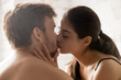 © fizkes - Close up of sensual young couple kissing in bedroom having romantic foreplay before sex, tender lovers caress making peace or reconcile after serious fight, boyfriend and girlfriend enjoy intimacy