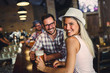 © lordn - Young cheerful people in the beer pub drinking and having good time. Friendship concept with young people enjoying time together and having genuine fun at cool vintage pub