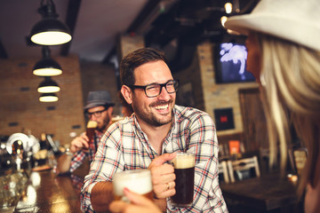 Wall Mural - Happy friends having fun at bar - Young trendy people drinking beer and laughing together