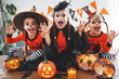 © JenkoAtaman - happy Halloween! a group of children in suits and with pumpkins in home