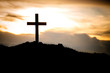 The silhouette cross standing on meadow sunset and flare background.Cross on a hill as the morning sun comes up for the day.The cross symbol for Jesus christ. Christianity, religious, faith, Jesus .
