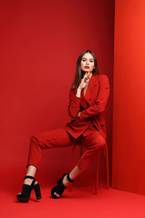 Fashion young woman in red suit.