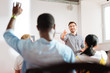 © zinkevych - Yes you. Cheerful friendly speaker conducting a business workshop and pointing to a student raising his hand
