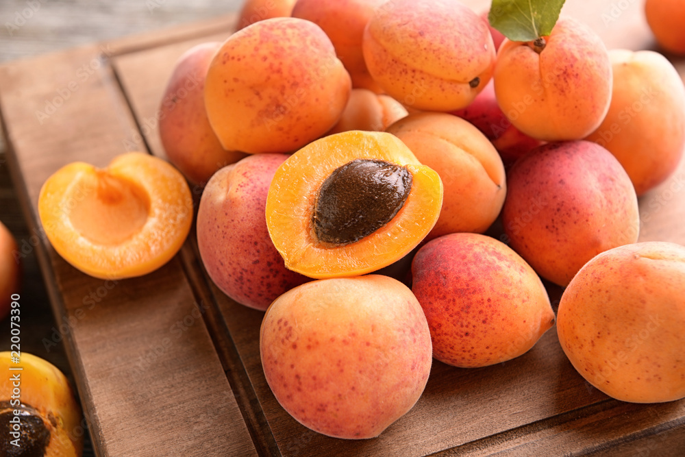 Sweet ripe apricots on wooden board, closeup
