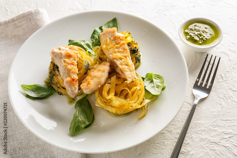 Plate of delicious pasta with chicken fillet on table