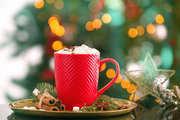 Cup of delicious cocoa on table against blurred Christmas lights