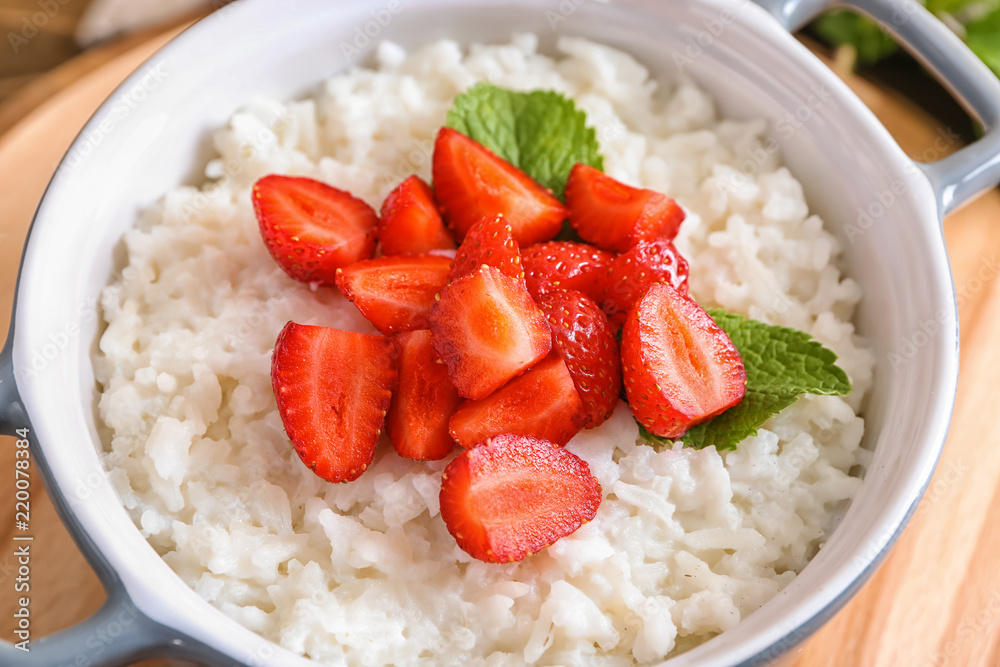 Bowl with delicious rice pudding and strawberry, closeup