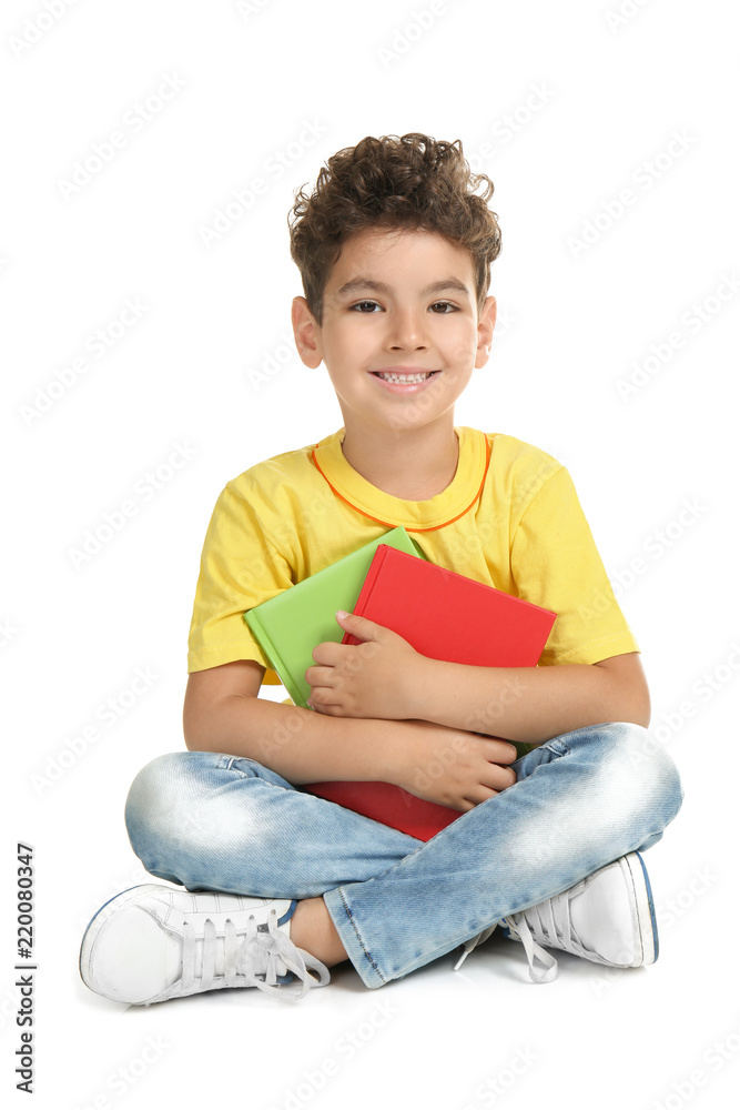 Cute little boy with books on white background