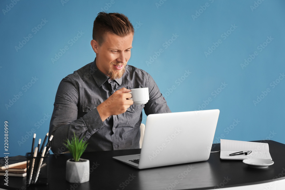 Young freelancer working on laptop in office