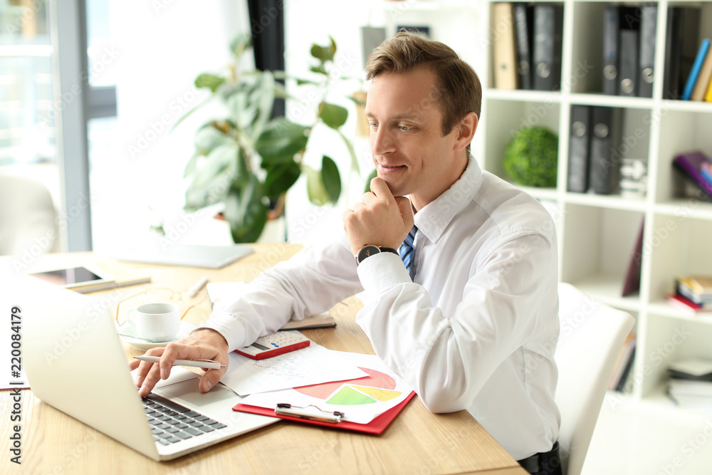 Businessman working with laptop in office