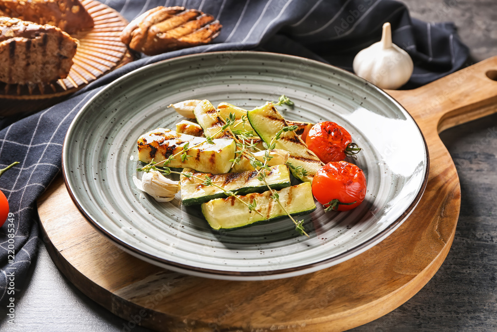Tasty grilled zucchini with tomatoes on plate