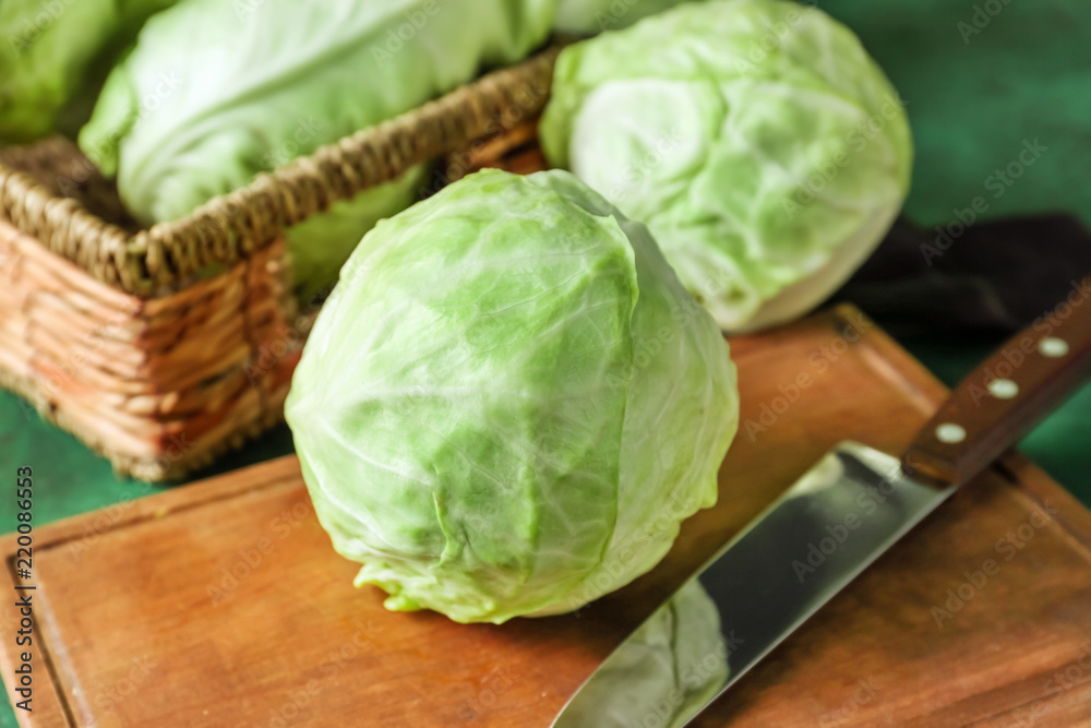 Fresh cabbage with knife on wooden board
