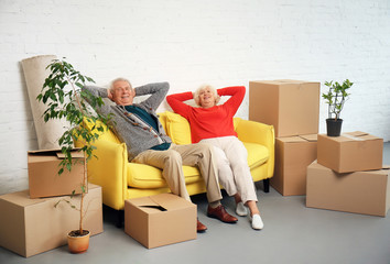 Sticker - Mature couple sitting on sofa near boxes after moving into new house