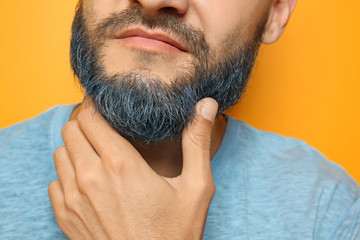 Poster - Handsome man with dyed beard on color background, closeup