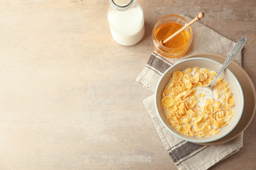 Wall Mural - Bowl with healthy cornflakes, milk and honey on light table