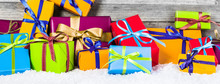Heap Of Brightly Colored Christmas Gifts On Snow