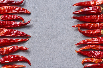 Wall Mural - top view of dried red chili peppers arranged on grey tabletop