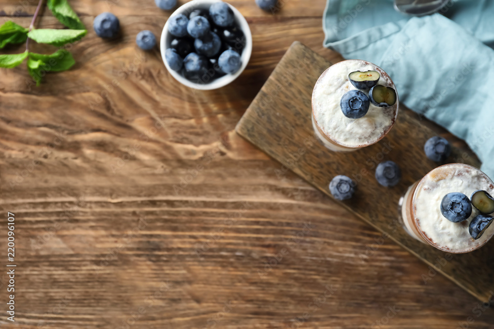 Glasses with delicious blueberry dessert on wooden table