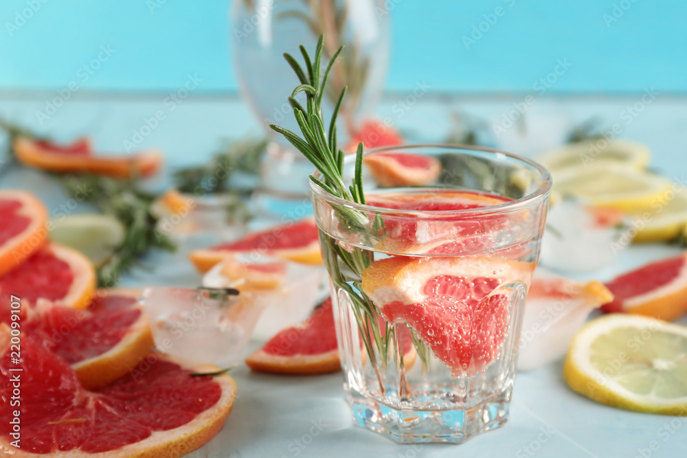 Fresh grapefruit cocktail with rosemary in glass on light table