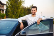 © Drobot Dean - Portrait of handsome businesslike man wearing suit, standing near his luxury black car with open driver's door
