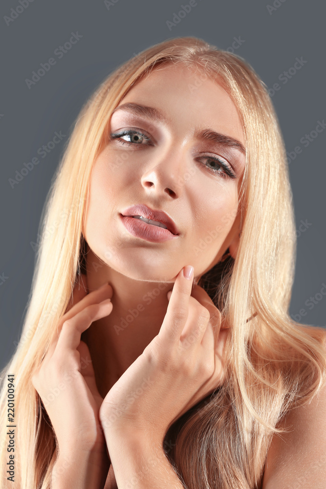 Beautiful young woman with pink lipstick on grey background