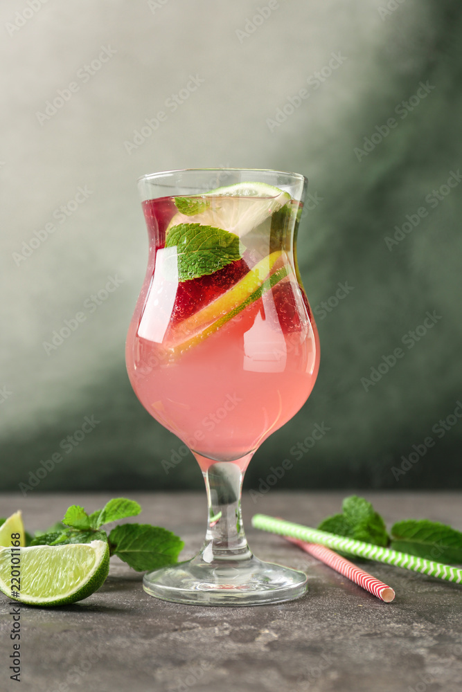 Glass of fresh raspberry mojito on grey table