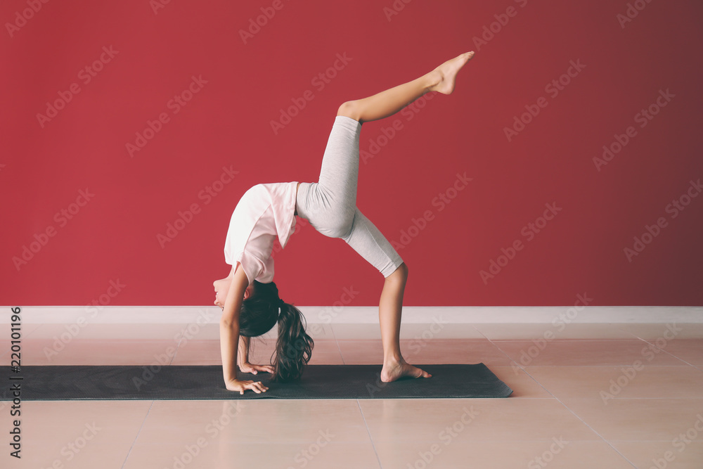 Little girl practicing yoga indoors