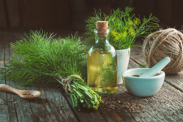 Wall Mural - Bunch of fresh green dill, mortar of fennel seeds, bottle of dill oil and jute.