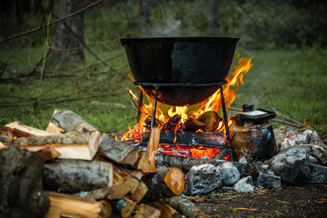 a cauldron for cooking is on the fire