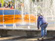 © sergei - a little boy playing near the city fountain