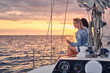 © Fxquadro - Female friends relaxing on the yacht with glasses of wine in the hands, during sunset on the high seas.