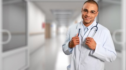 Wall Mural - Handsome male doctor with stethoscope on neck on background