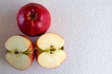 Wall Mural - an isolated red apple and two half apples on a white background