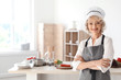 © New Africa - Professional female chef standing near table in kitchen