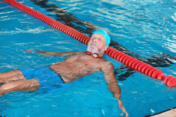 Wall Mural - Sportive senior man in indoor swimming pool