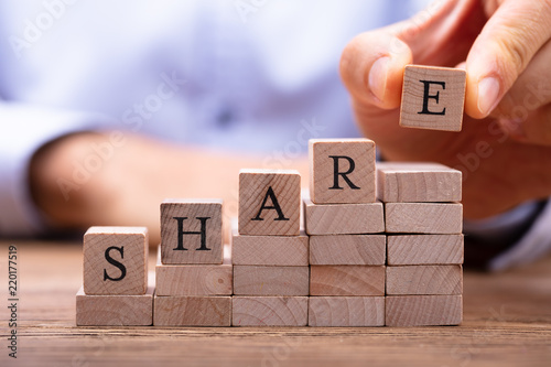 Cuadros en Lienzo Man's Hand Placing Last Alphabet Of Word Share