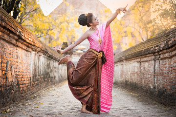 Beautiful Thai women dressed in traditional Thai clothes are dancing Thai at the historical park.