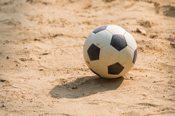 Classic black and white football soccer ball on sand