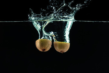 Wall Mural - Splashing kiwi fruit on the water