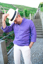 Funny Man In Hat Is Fooling Around Near Stone Stairs Outdoors