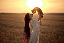 Sunset Photo Shoot Of A Girl With Dreadlocks In A White Dress In Wheat With A Cat