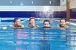 © Studio Romantic - A happy family is smiling in a swimming pool indoors.