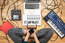 Young Woman Holding Studio Headphones, Point Of View Shot. Top View Of Female Producer At Home Studio With Modern Electronic Instruments.