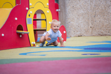 Wall Mural - Adorable baby boy, playing with different rides on the playgdorund